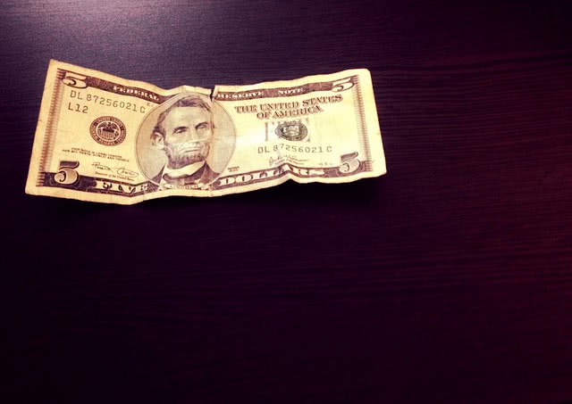 Five dollar bill slightly cramped.
