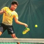 A person in yellow playing tennis.