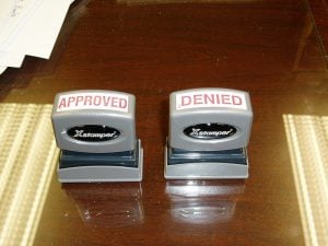 Two grey stampers, one says Approved, the other says Denied.