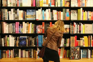 girl checking books on a shelf