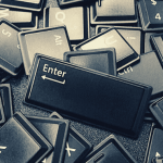 Keyboard keys scattered in a pile with the enter key sitting on top.