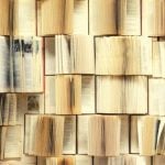 Rows of books opened towards the camera, with one large textbook standing out.