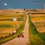 A tractor stopped by a wide farm road.