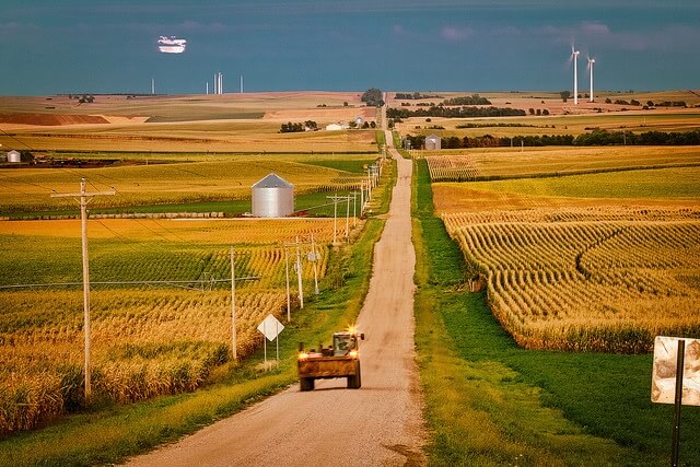 A tractor stopped by a wide farm road.