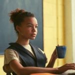 A teacher sitting at a desk in front of a computer.