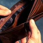 A student holding an empty wallet.