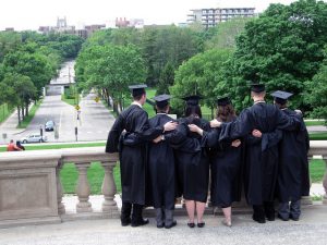 Back view of graduate students hugging each other.