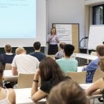 Students listening to a lecture by a professor in the classroom.