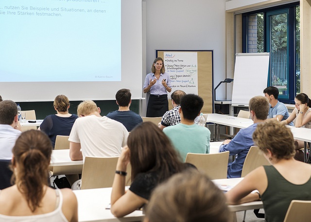 Students listening to a lecture by a professor in the classroom.