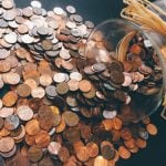 Coins spilled from a glass jar.