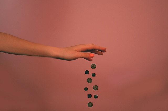 A hand is dropping coins.