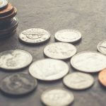 A stack of coins with more coins scattered around it.