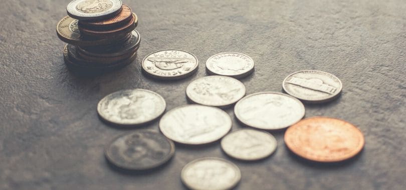 A stack of coins with more coins scattered around it.