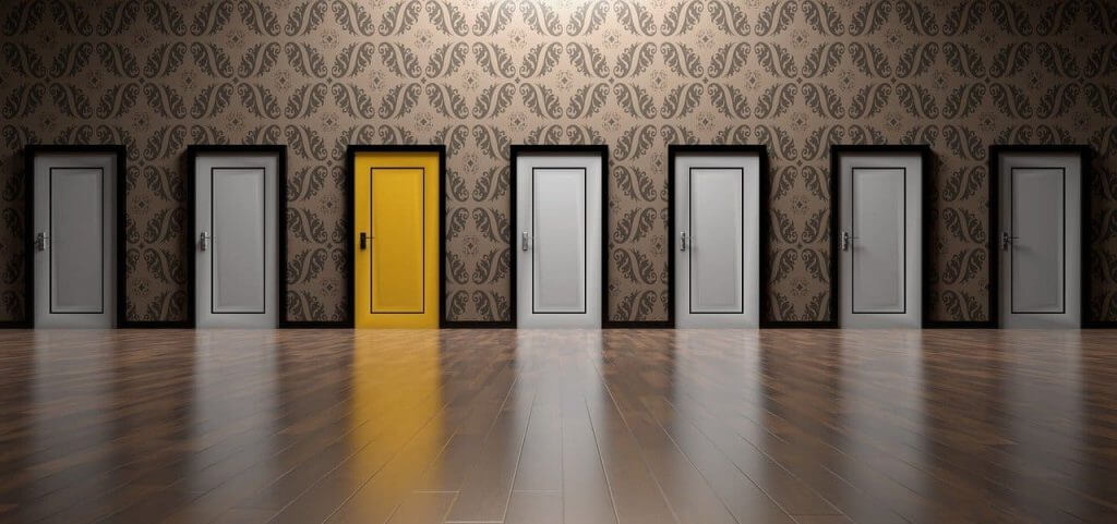 A row of gray doors with one yellow door.