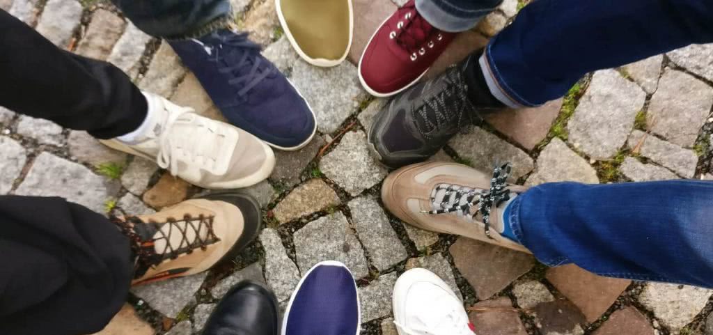 Students putting their shoes together in a circle.