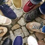 Students putting their shoes together in a circle.