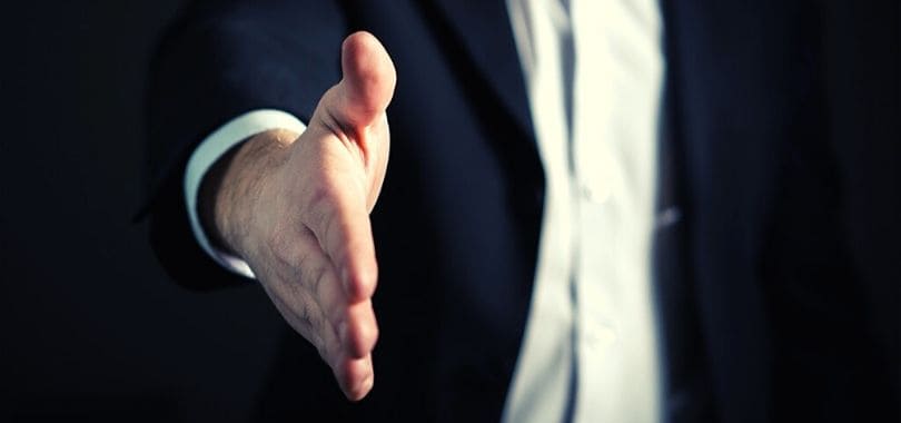 A business person offering a handshake.