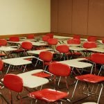 A Union College classroom with red chairs and white desks.