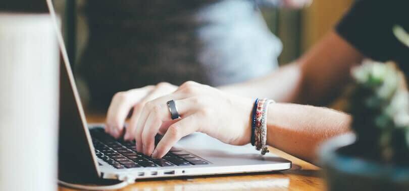 College student typing on a laptop.