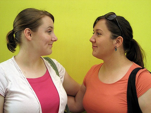 Two students facing each other and smiling.