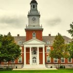 A shot of a Johns Hopkins University building with trees in front of it.