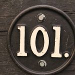 101 number in circular steel and is attached to wood.