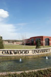 Oakwood University's name in brass lettering with the school building in the background.