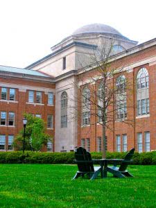 A lawn with a table and two chairs in front of a Davidson College campus building.