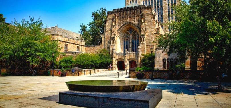 A college campus building with a sculpture in front of it.