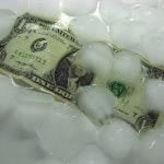 A dollar bill under melting ice cubes.