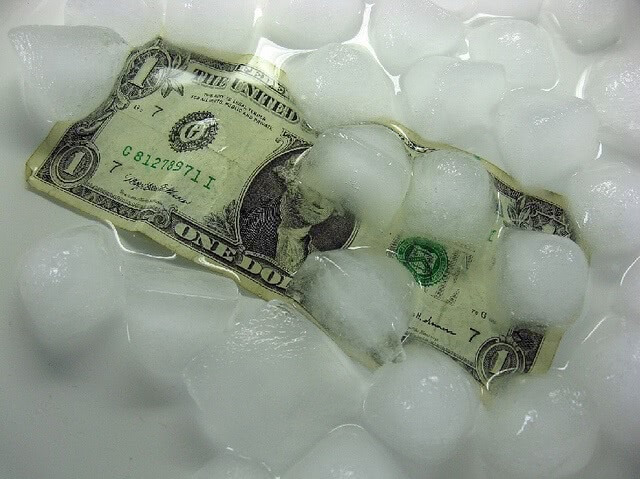 A dollar bill under melting ice cubes.