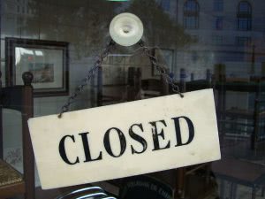 "Closed" signage behind a glass wall.