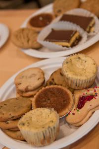 Two plates of assorted cupcakes and cookies.