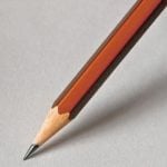 A brown pencil against a white piece of paper.