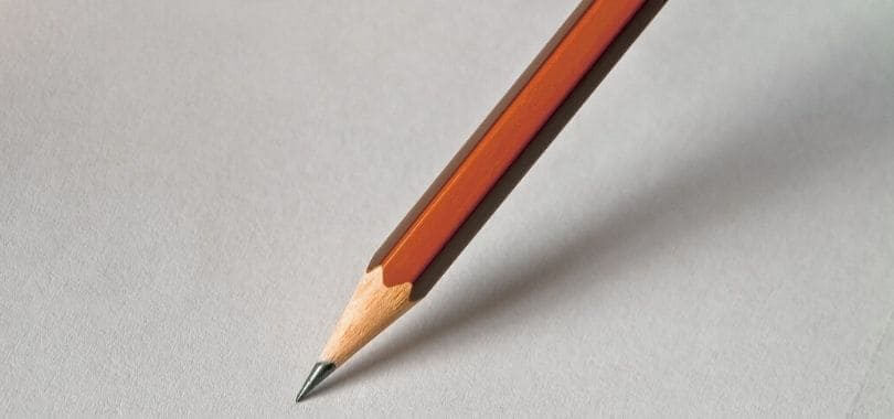 A brown pencil against a white piece of paper.