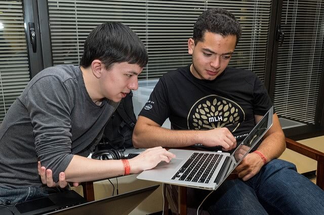 Two male students looking at the laptop.