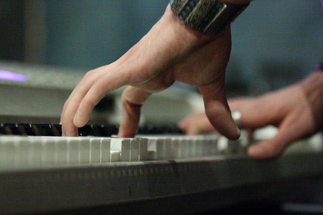 A hand is paying the piano shown below.