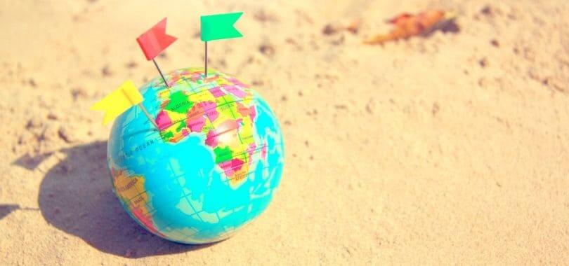 A small globe with colorful flags stuck in it.