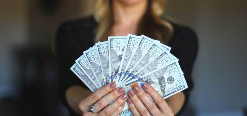 A person fanning out hundred dollar bills.