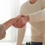 A student shaking hands with a professor.