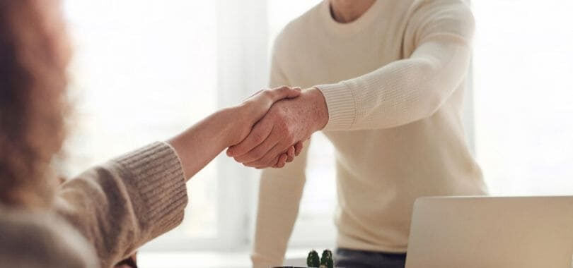 A student shaking hands with a professor.