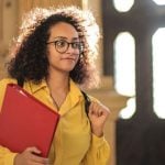 A student holding a red binder.