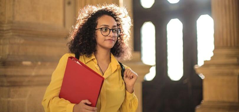 A student holding a red binder.