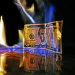 Five dollar bill burning with fire.