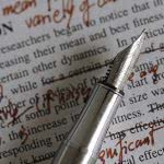 Like this pen and notes, proofreading your college essay can be messy but rewarding.