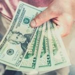 A student holding twenty dollar bills.