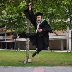 Graduate student jumps in excitement during his graduation day.
