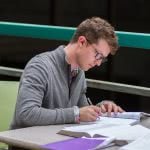 Male student studying at desk.