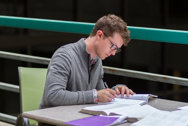 Male student studying at desk.