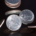 Close-up of coins falling onto a table.